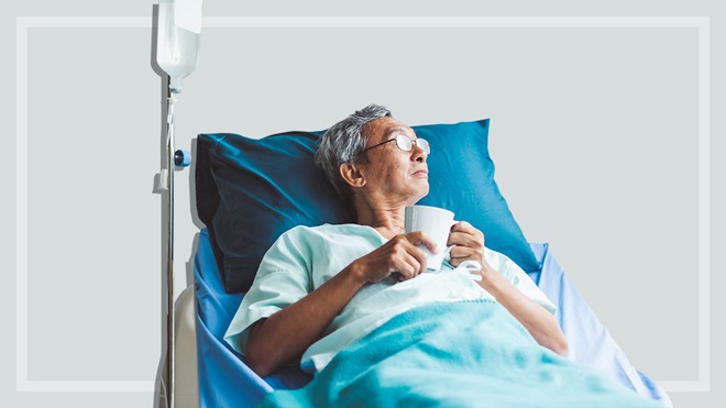 patient lying in a hospital bed holding a mug